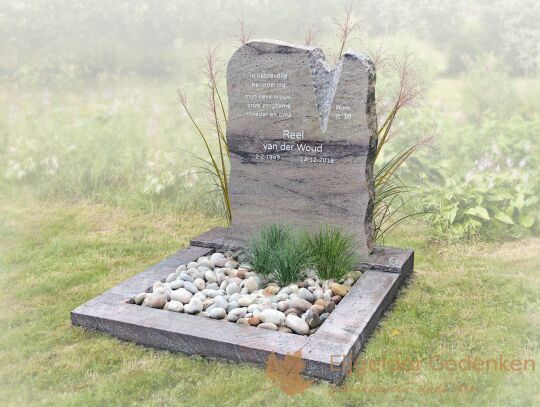 Kort grafmonument met ruwe lettersteen