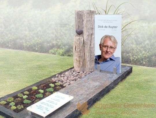 Modern glazen grafmonument met ruwe steensoorten