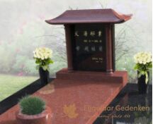 Chinees grafmonument met bloemen en plantenbak foto 2