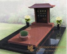 Chinees grafmonument met bloemen en plantenbak foto 1