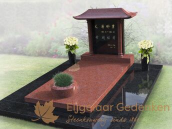 Chinees grafmonument met bloemen en plantenbak